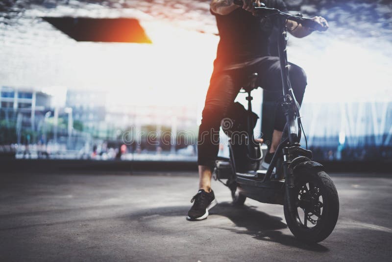 Hippie à la mode d'homme se préparant au tour en le scooter électrique dans la ville Transport innovateur photo stock Hippie à la mode d'homme se préparant au tour en le scooter électrique dans la ville Transport innovateur photo stock