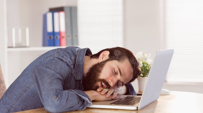 Hipster businessman sleeping at his desk in his office