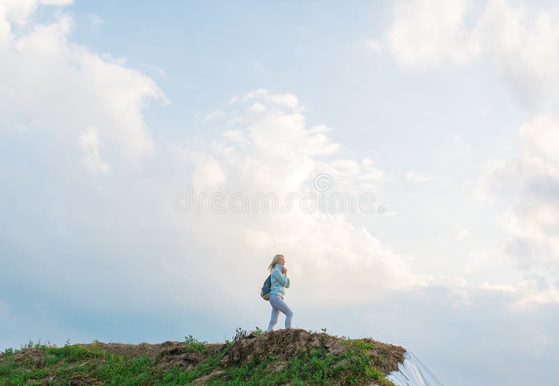 Hipster jong meisje die met rugzak van zonsondergang op piek van heuvel genieten royalty-vrije stock afbeelding Hipster jong meisje die met rugzak van zonsondergang op piek van heuvel genieten royalty-vrije stock afbeelding