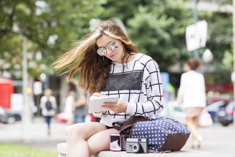 Hipster jonge vrouw die en nota's in stret reizen nemen stock foto's Hipster jonge vrouw die en nota's in stret reizen nemen stock foto's