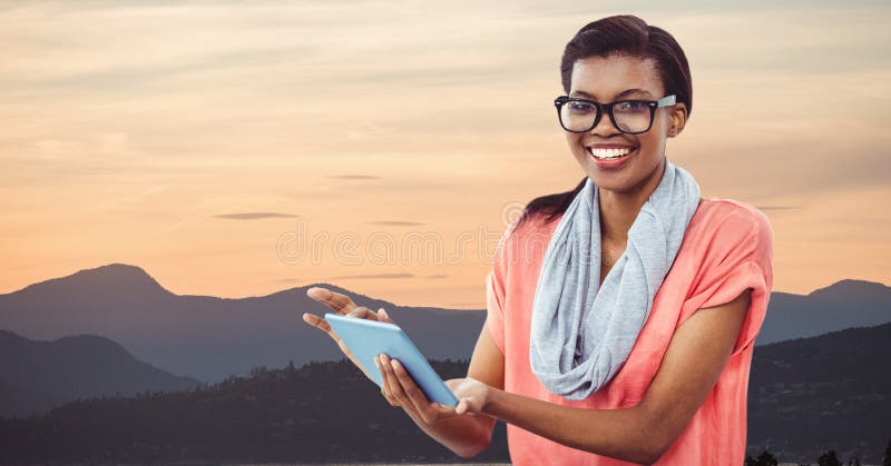 Hipster som rymmer den digitala minnestavlan, medan stå vid berg mot himmel arkivbild Hipster som rymmer den digitala minnestavlan, medan stå vid berg mot himmel arkivbild