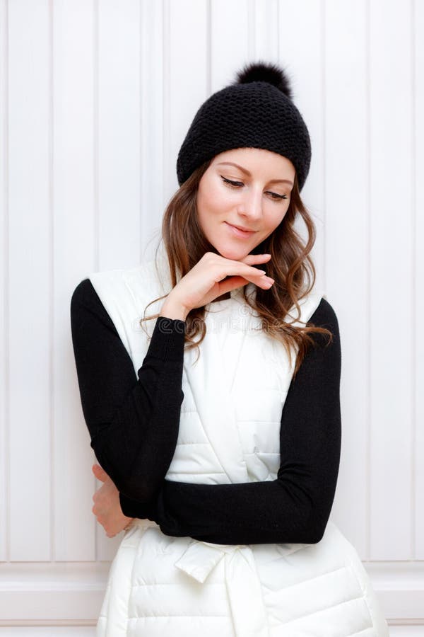 Hipster Style Brunette Girl Swag wearing Black fashion beanie knitted hat with bumbon pumpon. Season Fall Winter