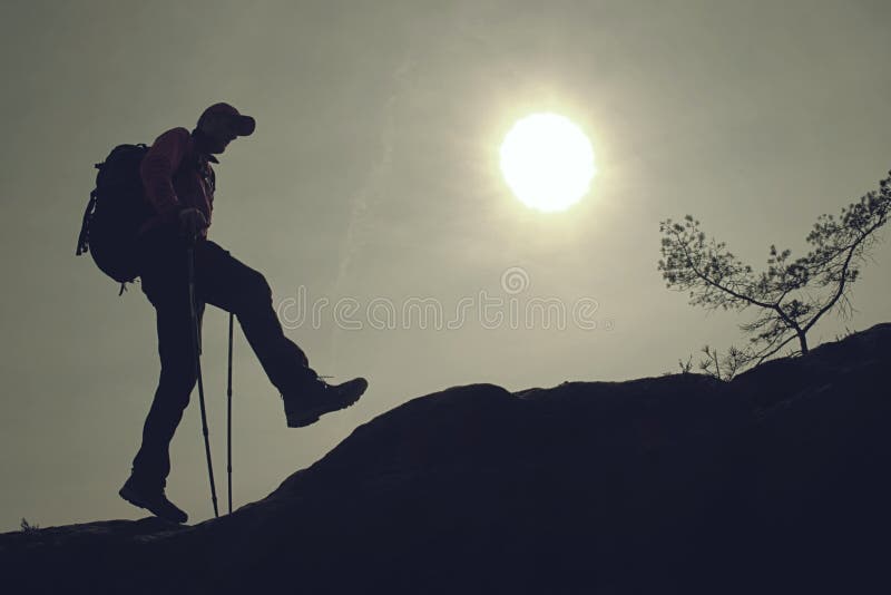 Hipster in sunglasses and a cap with big backpack and trekking sticks  stands on a high cliff. Sunset sky in  background of epic mountains contour watch walking uphill trees travel trail running track top standing sport runner real rain poles person people outdoor nature motion mist man male landscape journey hiker gear extreme explore edge clouds beautiful beard backpacker amazing adventure activity. Hipster in sunglasses and a cap with big backpack and trekking sticks  stands on a high cliff. Sunset sky in  background of epic mountains contour watch walking uphill trees travel trail running track top standing sport runner real rain poles person people outdoor nature motion mist man male landscape journey hiker gear extreme explore edge clouds beautiful beard backpacker amazing adventure activity