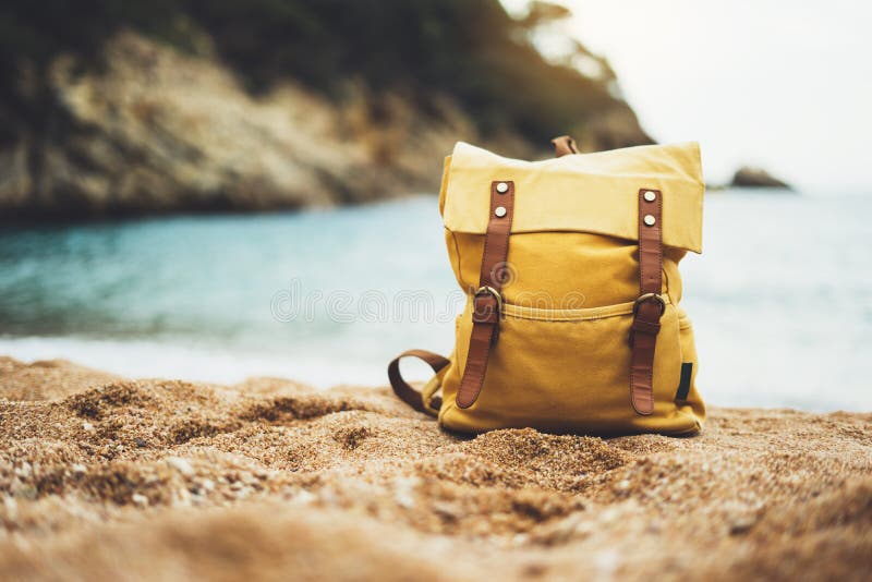 Hipster swimming mask on background blue sea ocean horizon, hiker tourist yellow backpack on sand beach, blurred panoramic seascap