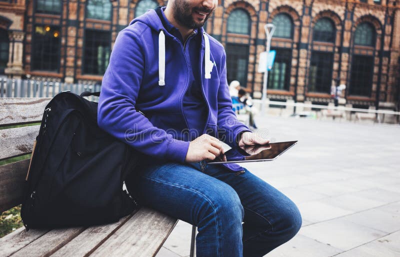 Hipster texting message on tablet computer or technology blank screen mockup. Smile young man using digital on building castle stock photography Hipster texting message on tablet computer or technology blank screen mockup. Smile young man using digital on building castle stock photography