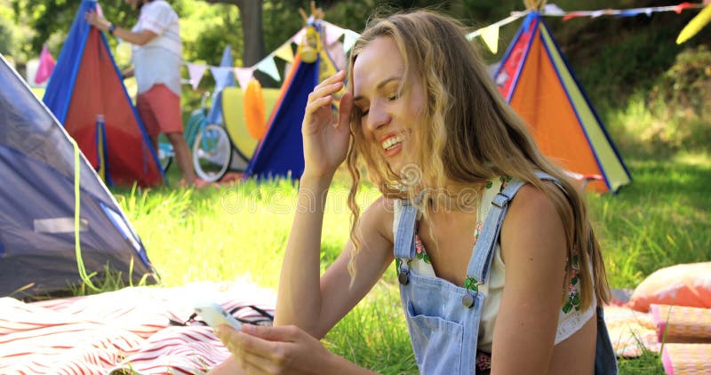 Hipsterkvinna som ser hennes mobiltelefon