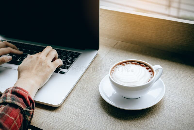 Hipsterman som arbetar på bärbara datorn i en coffee shop arkivbild Hipsterman som arbetar på bärbara datorn i en coffee shop arkivbild