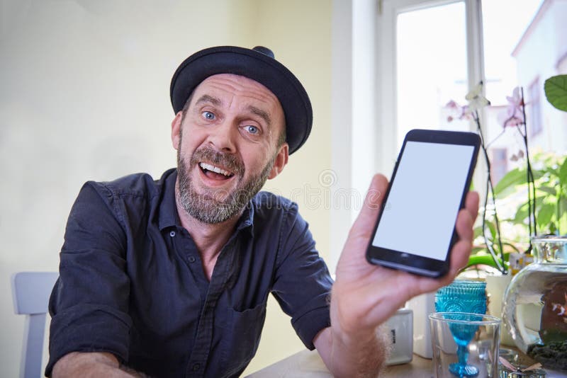 Hipstervisningtelefon till kameran som förvånas lyckligt royaltyfria foton Hipstervisningtelefon till kameran som förvånas lyckligt royaltyfria foton