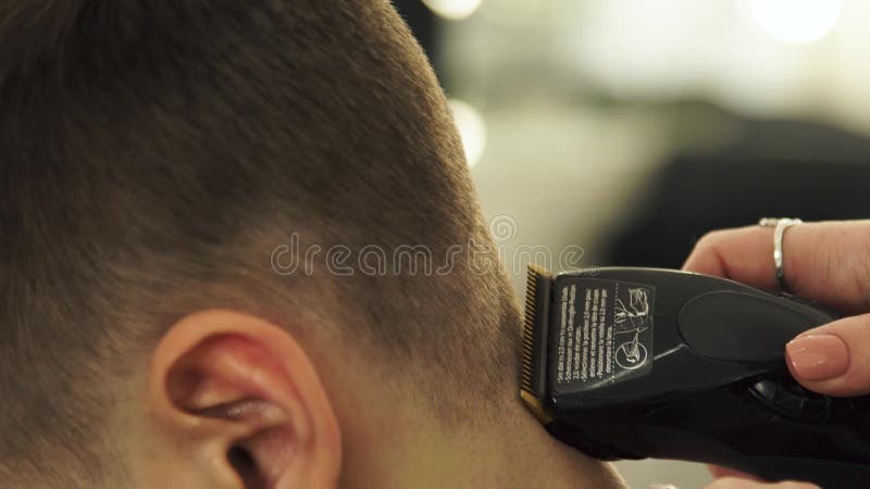Hirdresser que faz o corte de cabelo com lâmina elétrica Feche acima do cabelo do corte do barbeiro com a máquina profissional do vídeos de arquivo Hirdresser que faz o corte de cabelo com lâmina elétrica Feche acima do cabelo do corte do barbeiro com a máquina profissional do vídeos de arquivo