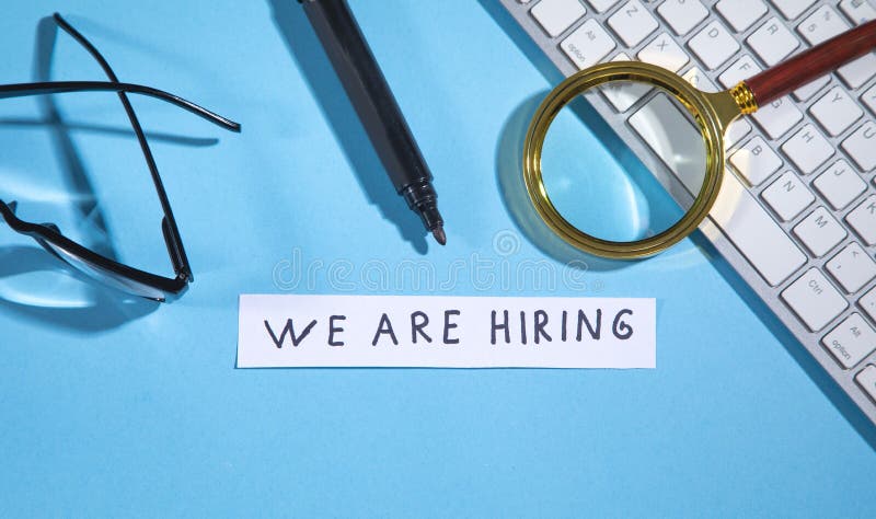 We Are Hiring on paper with a computer keyboard, marker