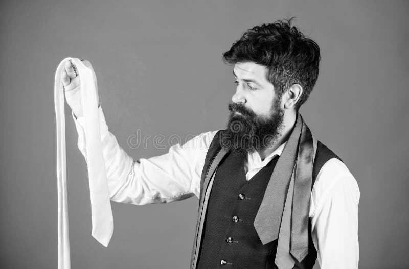 His wardrobe presents his style sense. Bearded man choosing a necktie from his wardrobe. Stylish mens wardrobe for business or formal occasions. Creating a very effective formal wardrobe background.