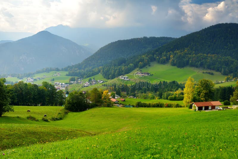 Hisnande lansdcape av berg, skogar och små bayerska byar i avståndet Scenisk sikt av bayerska fjällängar med mest majest