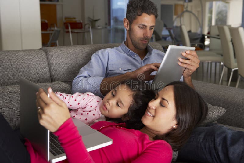 Hispanic Family On Sofa Using Laptop And Digital Tablet royalty free stock photo Hispanic Family On Sofa Using Laptop And Digital Tablet royalty free stock photo