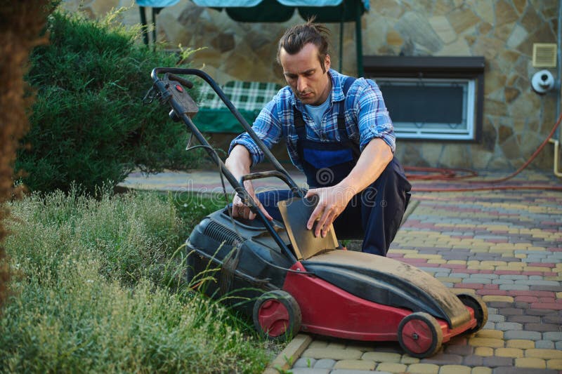 Hispanic Gardener in Blue Work Uniform, Taking the Cut Grass Out of the