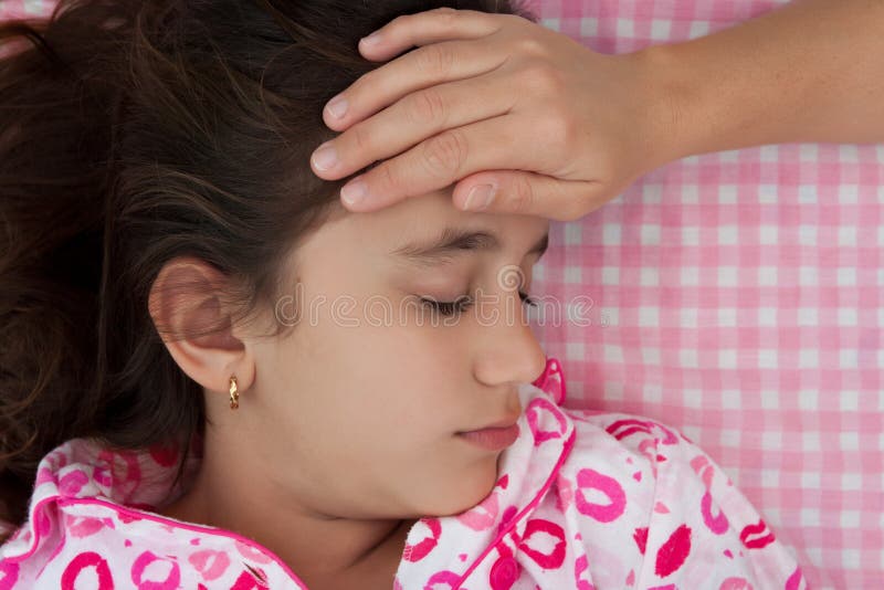 Hispanic girl sick with fever laying in bed stock photography