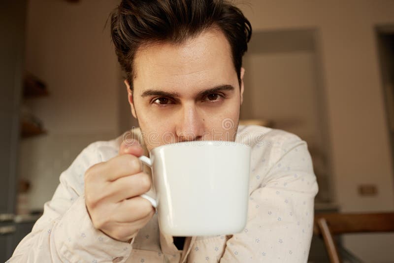 Hispanic Handsome Man Holding White Cup of Coffee at Home Stock Image