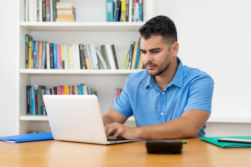 Hispanic hipster man with beard working with concentration at computer royalty free stock photography