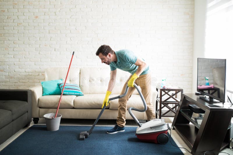 Hispanic man vacuuming the living room royalty free stock image Hispanic man vacuuming the living room royalty free stock image