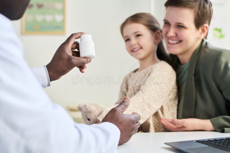 Smiling Family Visiting Doctor Holding Prescription Bottle stock photography