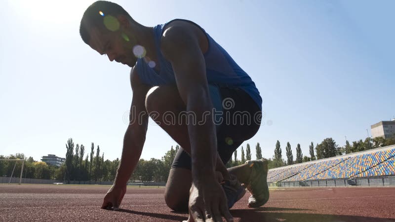 Hispanic runner in starting position to run on track, goal achievement in sport royalty free stock photo Hispanic runner in starting position to run on track, goal achievement in sport royalty free stock photo