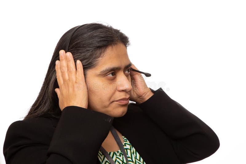 Hispanische Geschäftsfrau Puts On Headset für Anruf stockfoto Hispanische Geschäftsfrau Puts On Headset für Anruf stockfoto