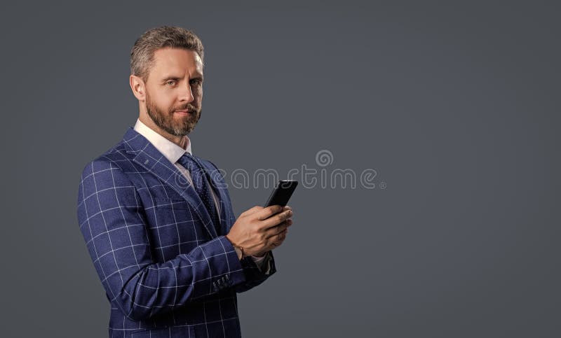Hispanischer Geschäftsmann mit Telefon. Unternehmer telefonisch. Telefongespräch isoliert auf Grau. Geschäftsmann chattet stockbild
