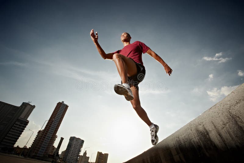 Hispanischer Mann, der von einer Wand läuft und springt lizenzfreies stockfoto Hispanischer Mann, der von einer Wand läuft und springt lizenzfreies stockfoto