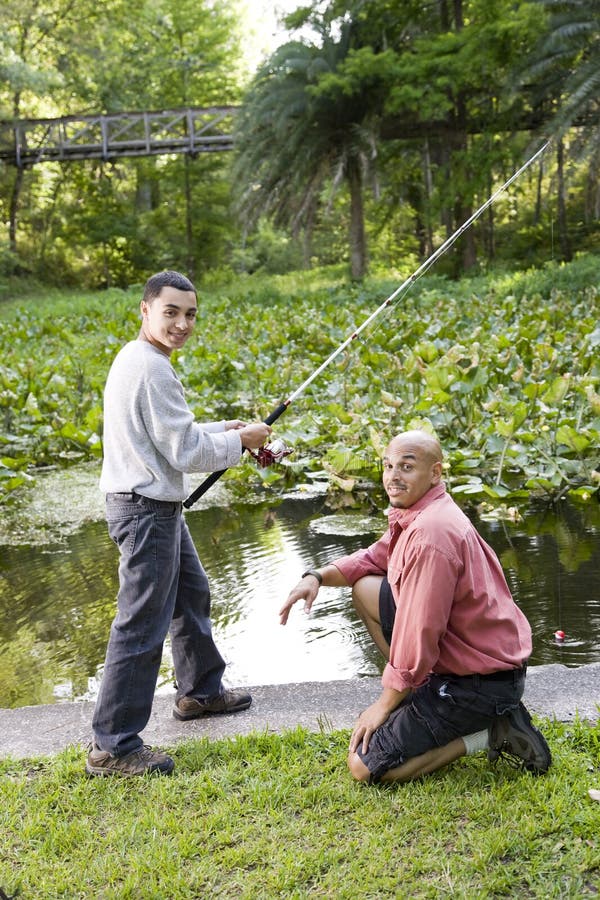 Hispanisches Jugendlich Und Vaterfischen Im Teich Stockfoto Bild von