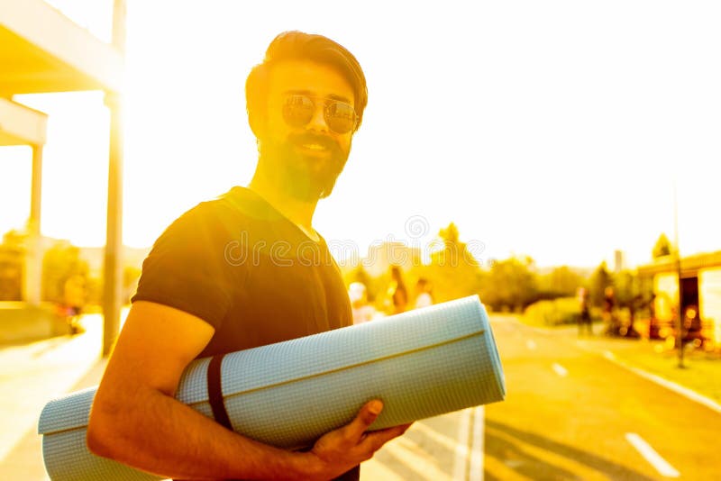 Hispano con camiseta de algodón negro listo para el yoga al atardecer en el parque de verano luces doradas al aire libre fotografía de archivo