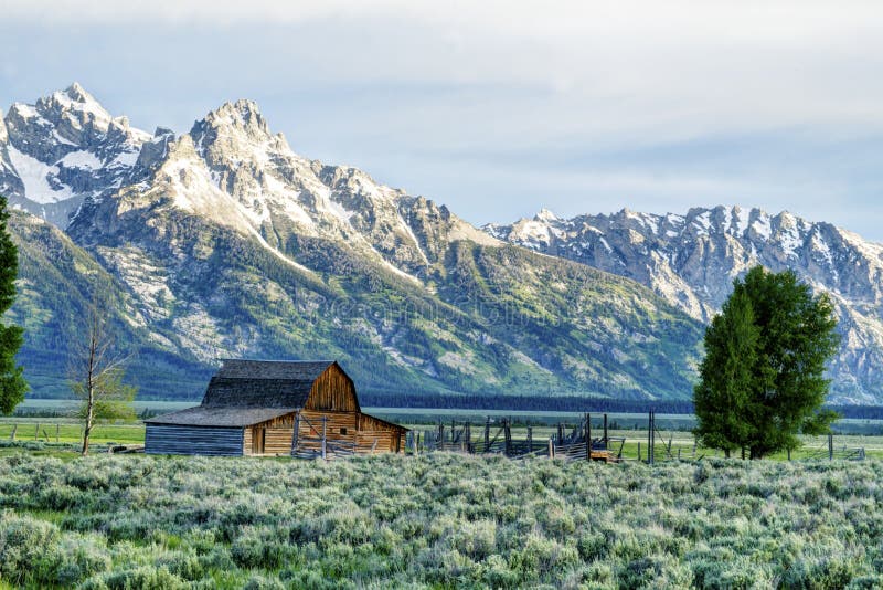 Historic buildings below snow capped mountains in The Grand Tetons.