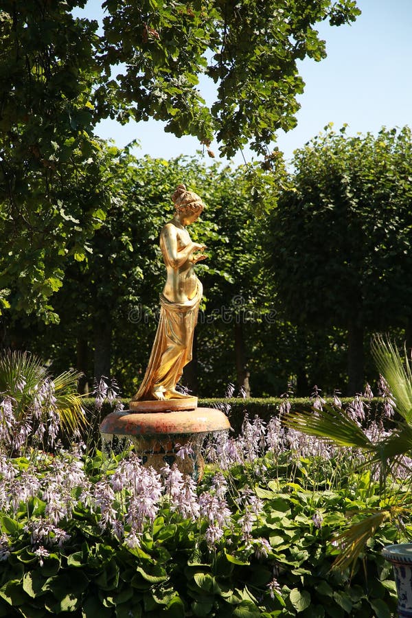 Bell Fountain With A Female Gilded Figure In The Garden Near The