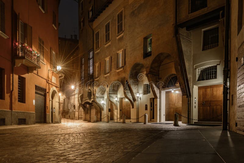 Historical street of bologna italy at night. With street lantern light and stone pavement reflecting.Historical medieval palace in backgroung with old windows royalty free stock image Historical street of bologna italy at night. With street lantern light and stone pavement reflecting.Historical medieval palace in backgroung with old windows royalty free stock image