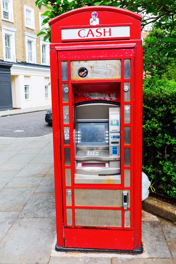 Historisk röd telefonask som bankomaten, London, UK arkivfoton Historisk röd telefonask som bankomaten, London, UK arkivfoton