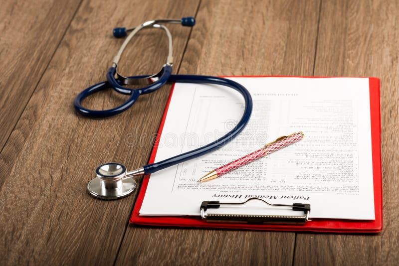 Medical history with stethoscope and pen on wooden desk. Medical history with stethoscope and pen on wooden desk