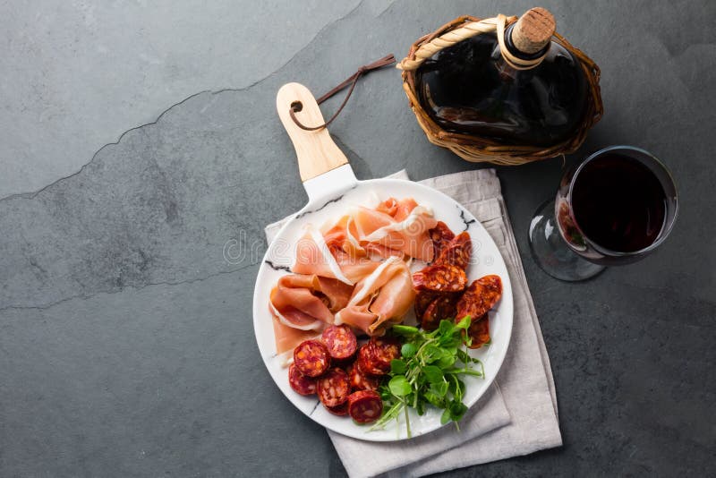 Hiszpański baleronu serrano, salami na biel wykładającym marmurem talerzu i czerwone wino Odgórny widok obrazy royalty free Hiszpański baleronu serrano, salami na biel wykładającym marmurem talerzu i czerwone wino Odgórny widok obrazy royalty free