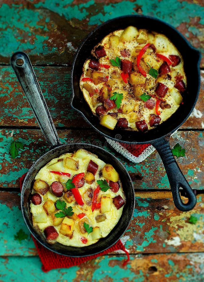 Hiszpański tortilla z grulami i kiełbasami w małych smaży nieckach Odgórny widok zdjęcie stock Hiszpański tortilla z grulami i kiełbasami w małych smaży nieckach Odgórny widok zdjęcie stock
