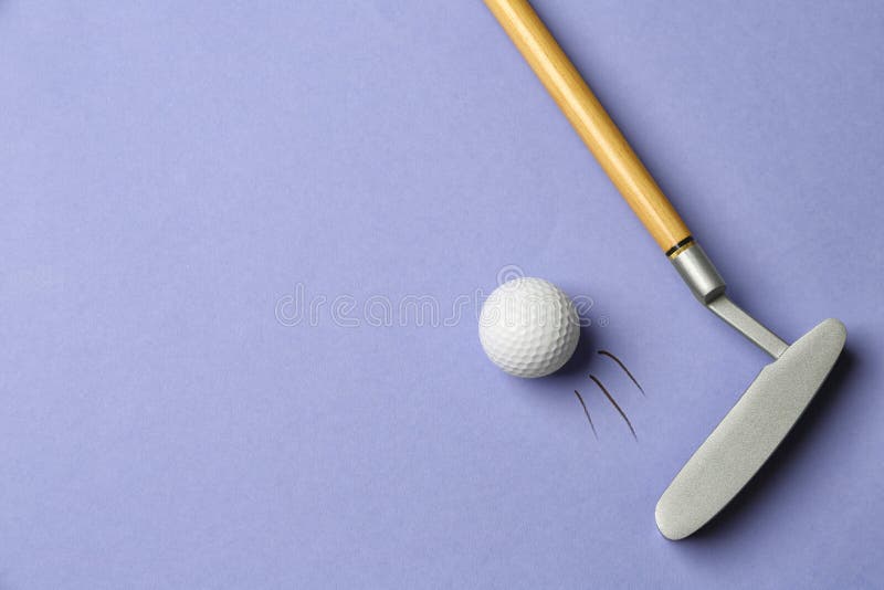 Hitting golf ball with club on lilac background - creative image royalty free stock photography Hitting golf ball with club on lilac background - creative image royalty free stock photography