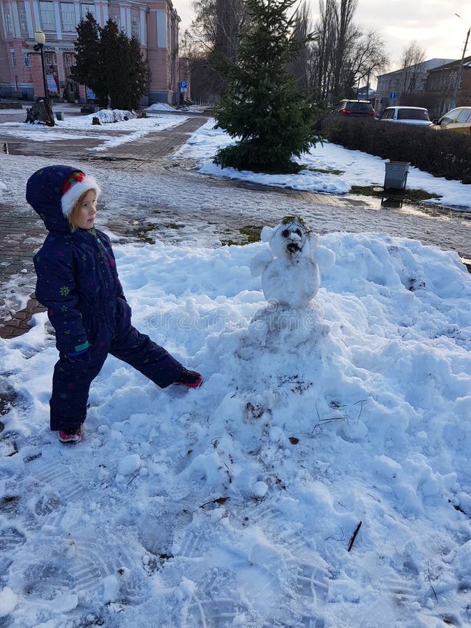 Hiver russe, fille et un bonhomme de neige photos stock Hiver russe, fille et un bonhomme de neige photos stock