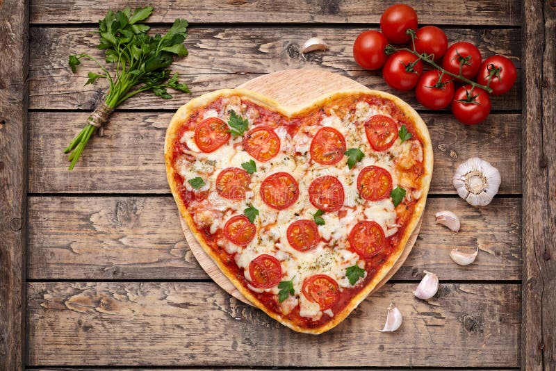 Hjärta format begrepp för mat för förälskelse för pizzamargherita romantiskt med mozzarellaen, tomater, persilja och vitlöksamman royaltyfri bild Hjärta format begrepp för mat för förälskelse för pizzamargherita romantiskt med mozzarellaen, tomater, persilja och vitlöksamman royaltyfri bild