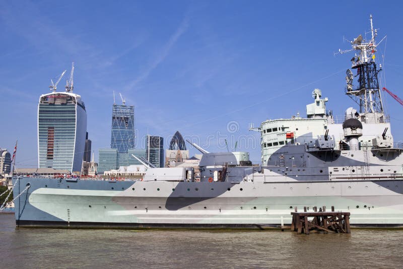 The HMS Belfast moored on the River Thames in London. In the background you can the Walkie Talkie building under construction and the Gherkin. The HMS Belfast moored on the River Thames in London. In the background you can the Walkie Talkie building under construction and the Gherkin.