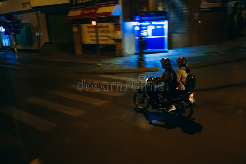 HO CHI MINH, VIETNAM - CIRCA MAART, 2017: Man en vrouw die een motor berijden bij nacht stock fotografie HO CHI MINH, VIETNAM - CIRCA MAART, 2017: Man en vrouw die een motor berijden bij nacht stock fotografie