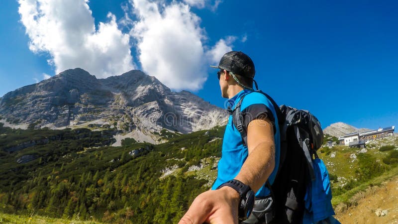Hochtor человек с selfie whie пеший туризм. Человек с selfie, в то время как пешие прогулки в зеленом зеленом альпийском регионе в Австрии. Небо синее с одним облака на него. Склоны гор перерастанные с кустами и травы. Лето в альпах. Изучить природу