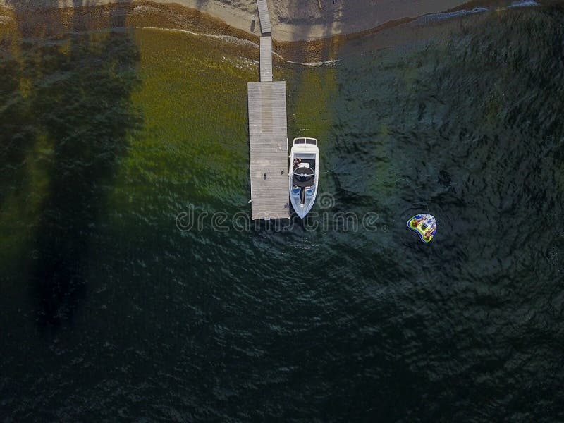 Hochwinkelaufnahme eines Schiffes neben einem Holzsteg auf einem See lizenzfreies stockbild Hochwinkelaufnahme eines Schiffes neben einem Holzsteg auf einem See lizenzfreies stockbild