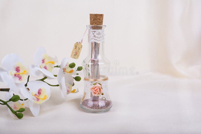Hochzeitseinladung in der Glasflasche und in der Orchidee blüht lizenzfreie stockfotos Hochzeitseinladung in der Glasflasche und in der Orchidee blüht lizenzfreie stockfotos