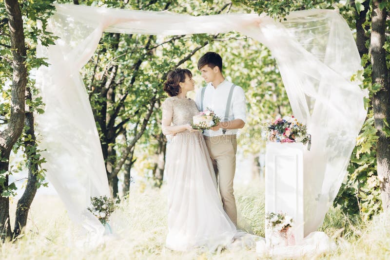 Hochzeitspaare auf Natur Braut und Bräutigam mit Kuchen an der Hochzeit stockfotografie Hochzeitspaare auf Natur Braut und Bräutigam mit Kuchen an der Hochzeit stockfotografie