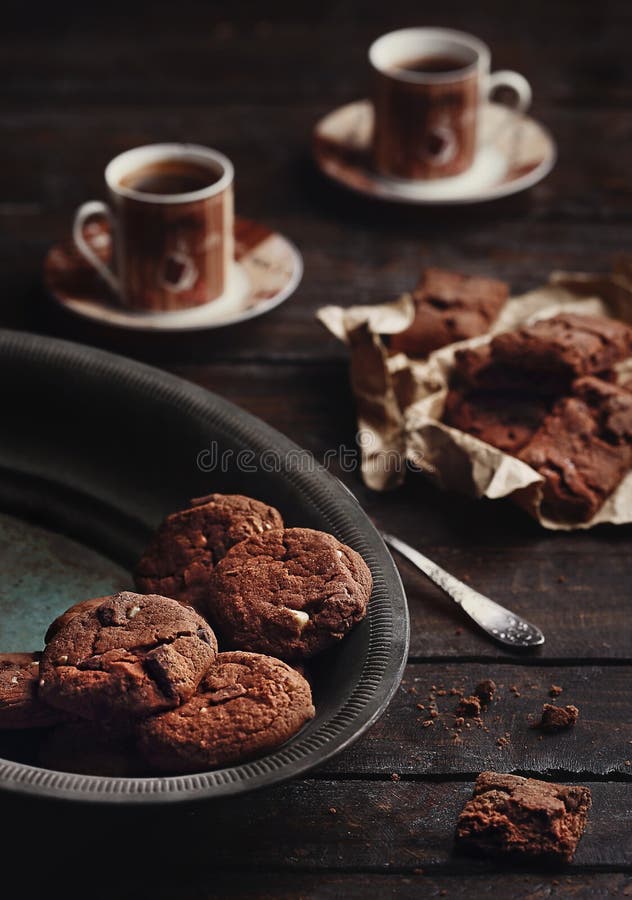 Homemade chocolate cookies and 2 cups of coffee on a dark wooden table. Homemade chocolate cookies and 2 cups of coffee on a dark wooden table