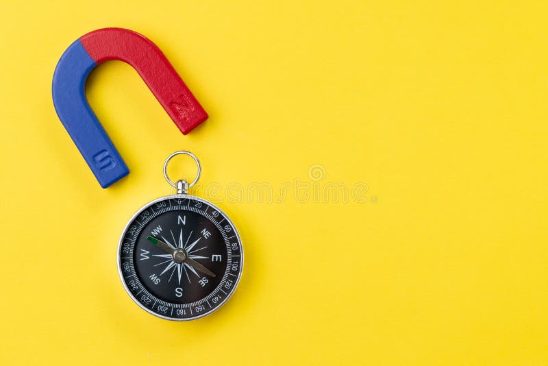 Hoefijzermagneet met blauw en rood met kompas op levendige gele achtergrond met exemplaar het ruimte gebruiken voor speciale krac