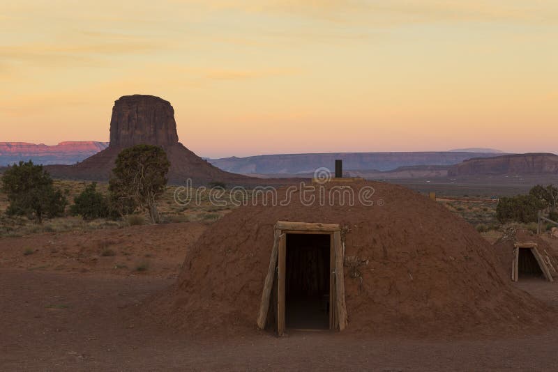 Hogan de Navajo au lever de soleil avec une butte à l'arrière-plan images libres de droits Hogan de Navajo au lever de soleil avec une butte à l'arrière-plan images libres de droits