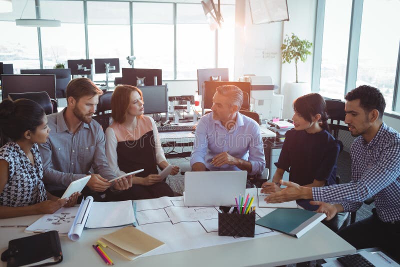 Hoge hoekmening van creatieve bedrijfscollega's die rond bureau bespreken royalty-vrije stock foto's Hoge hoekmening van creatieve bedrijfscollega's die rond bureau bespreken royalty-vrije stock foto's