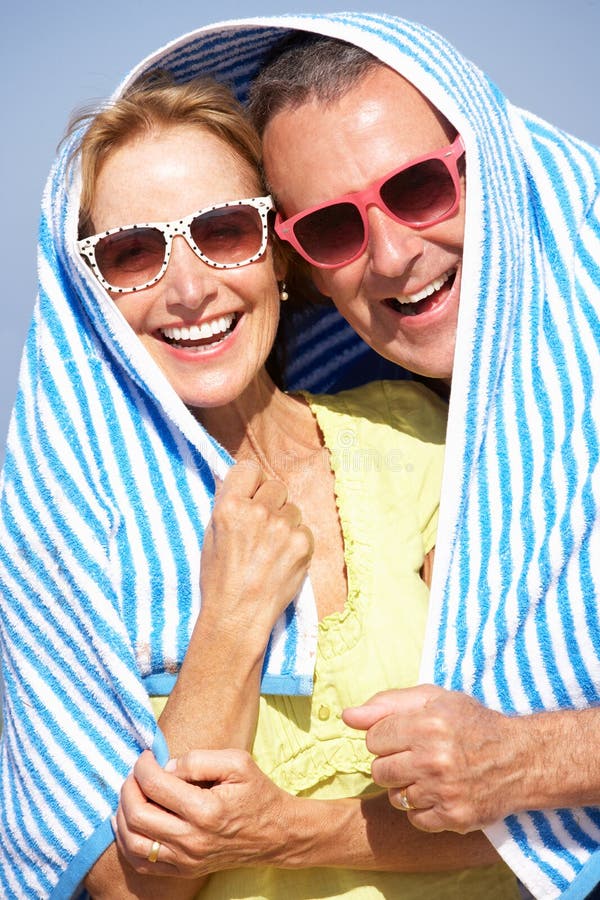 Hoger Paar dat van Zon op de Vakantie van het Strand beschut stock foto's Hoger Paar dat van Zon op de Vakantie van het Strand beschut stock foto's